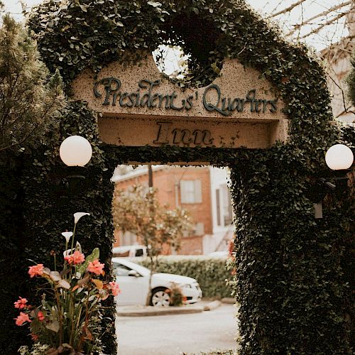 The image shows an ivy-covered archway with a sign reading 